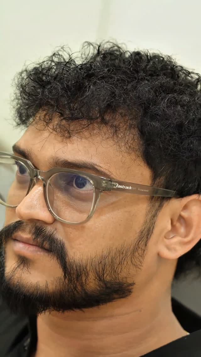 A shaped beard and natural curls finished in the men's chair