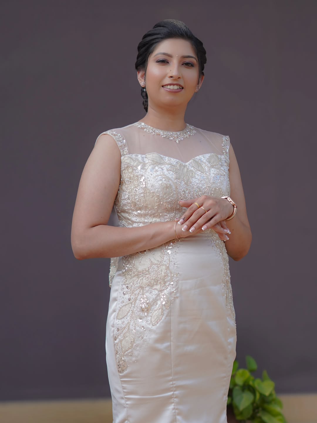 A reception gown look with a sleek braided updo